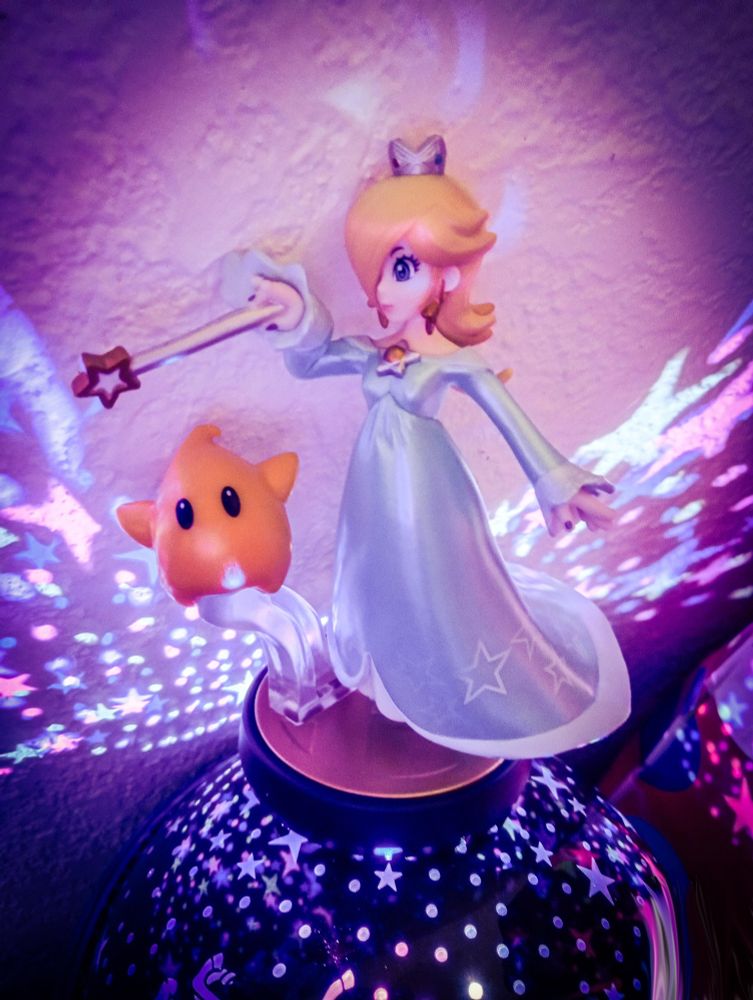 Rosalina and Luma amiibo, standing on a light projector 
