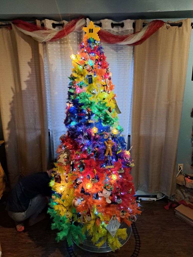 Rainbow christmas tree decorated and topped with a Mario Bros. Star