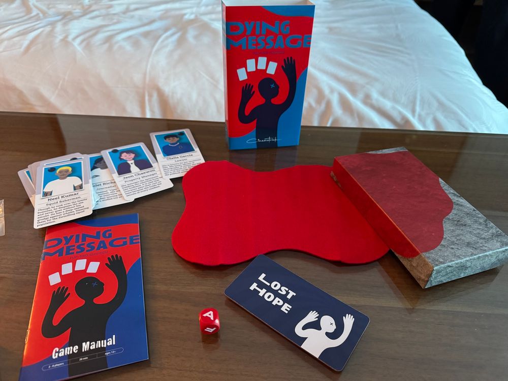 Dying Message, a game featuring a felt bloodstain, cards with murder suspects, a die with letters, and a "lost hope" card.