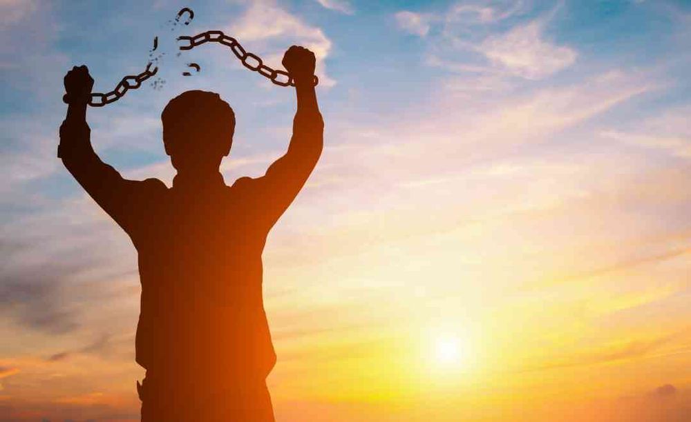stock photo image meme with the silhouette of someone breaking chains on their wrists against a sunset