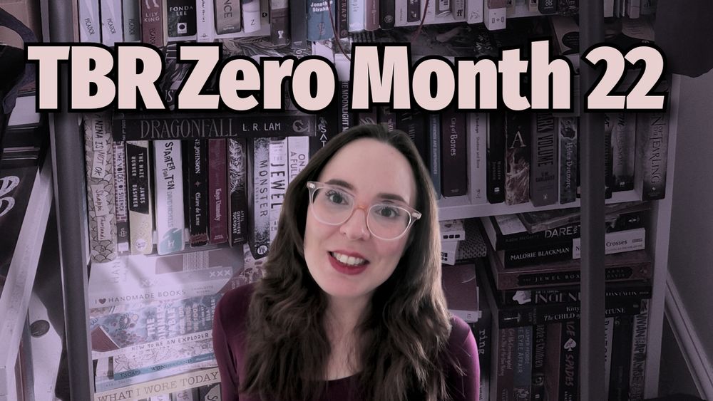 The thumbnail image from the video - me, a very pale white woman with dark brown hair and eyes wearing translucent pale pink glasses and a dark burgundy long sleeved top, superimposed on top of a desaturated picture of my bookshelves. At the top are the words "TBR Zero Month 22"