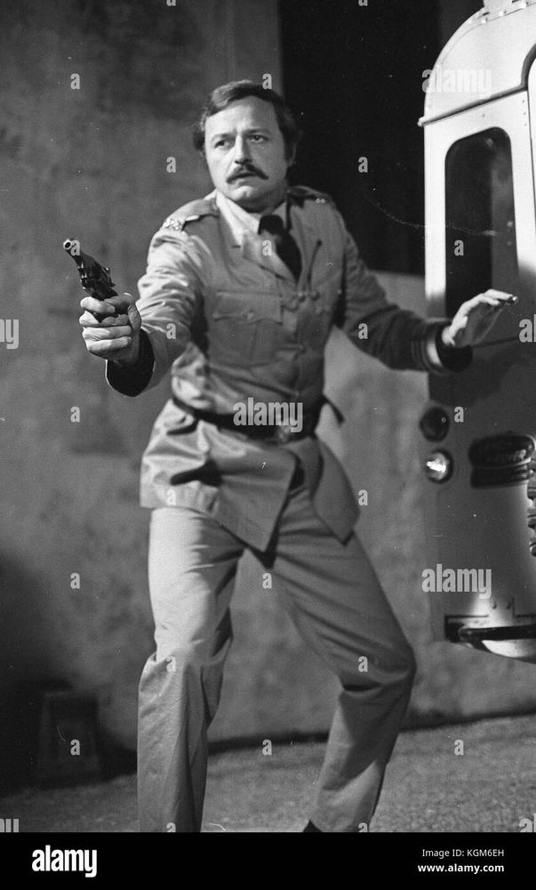 Black and white picture of Peter Bowles, holding a pistol, in a scene from the 1970 film Eyewitness.