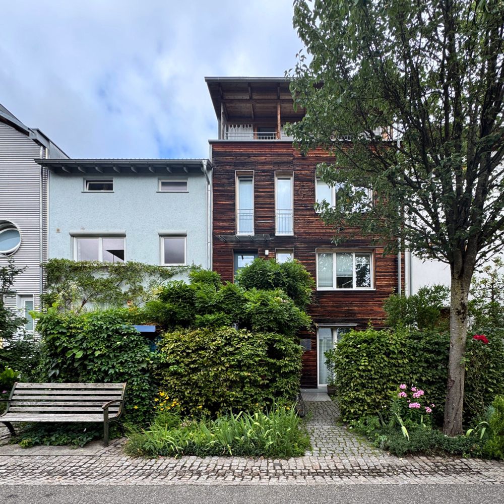 A street scene from Vauban showing row houses of slightly different heights, with green front gardens 