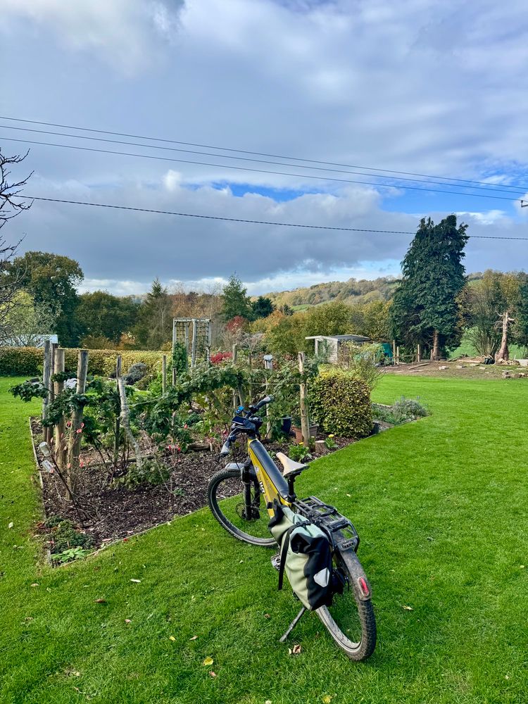 Herefordshire landscape with rolling hills in the background, productive garden in the foreground and an ebike parked alongside.