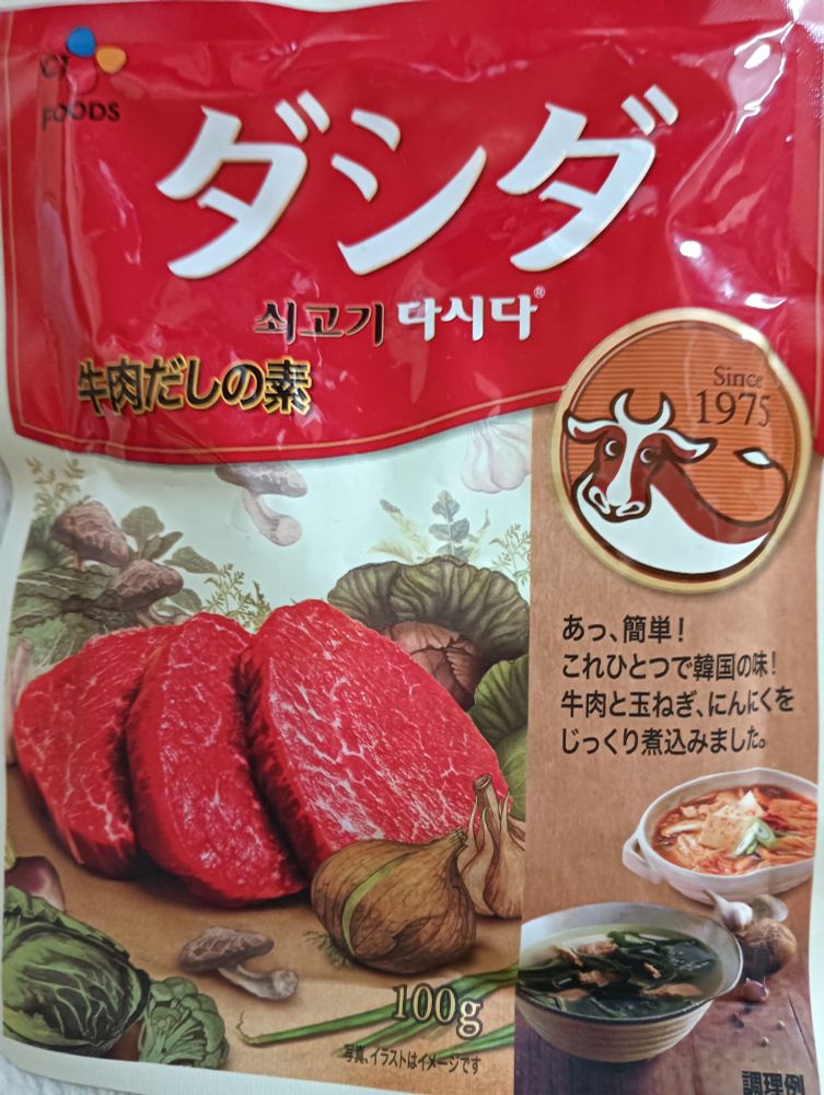 「ダシダ
牛肉だしの素」と書かれた袋。牛肉のきれと、スープの絵。「あっ、簡単！
これひとつで韓国の味！
牛肉と玉ねぎ、にんにくをじっくり煮込みました」とある。韓国からの輸入食材らしく、韓国語の文字も書いてあるのだが、私（小夏）が読めないため割愛します。