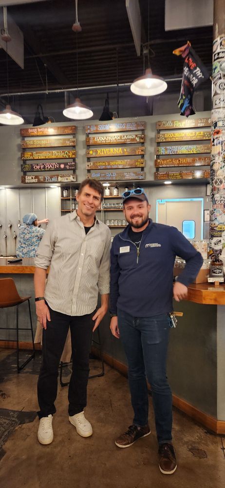 Will and Dr. Richard Marks standing together by the bar at Haw River Tap and Table.