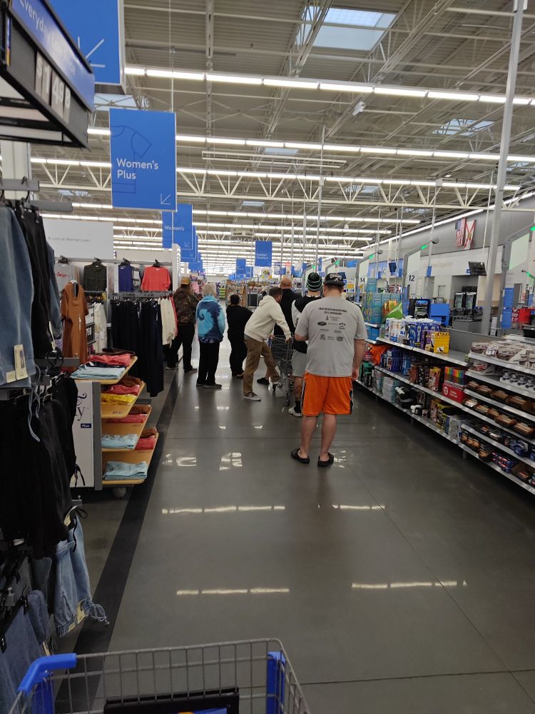 About 6 men waiting patiently for pokemon cards to be restocked.