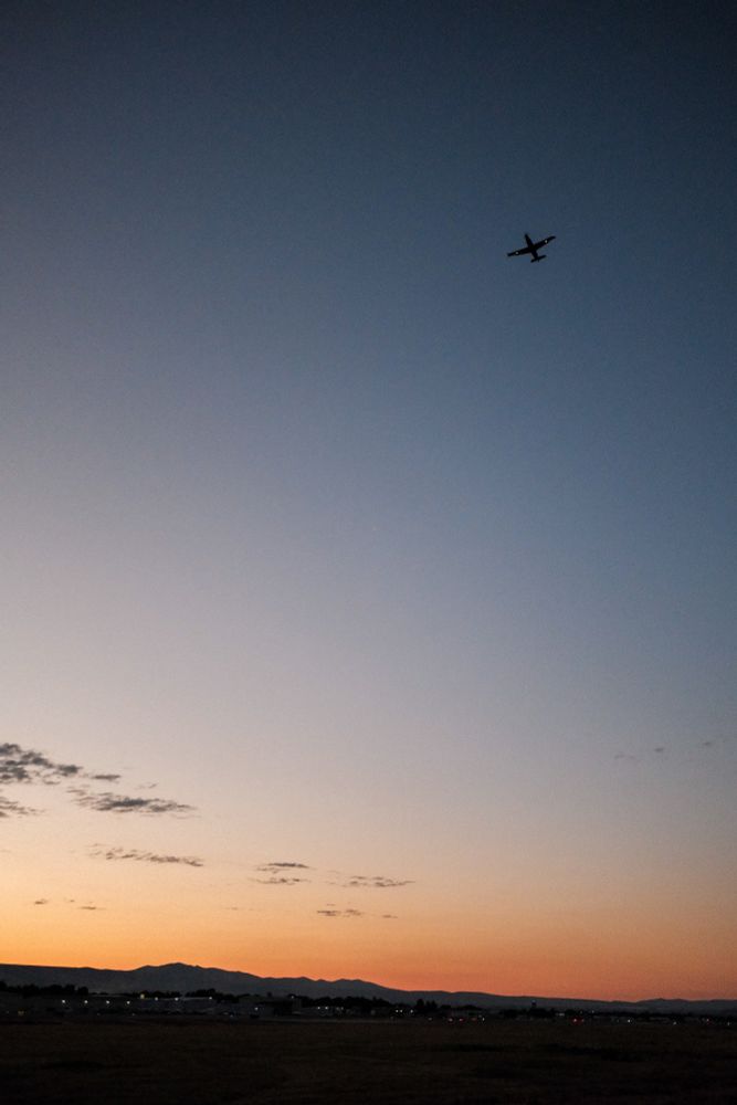 Pilatus PC-12 on take off. A simple almost clear sunrise background. The hills low in the distance. 