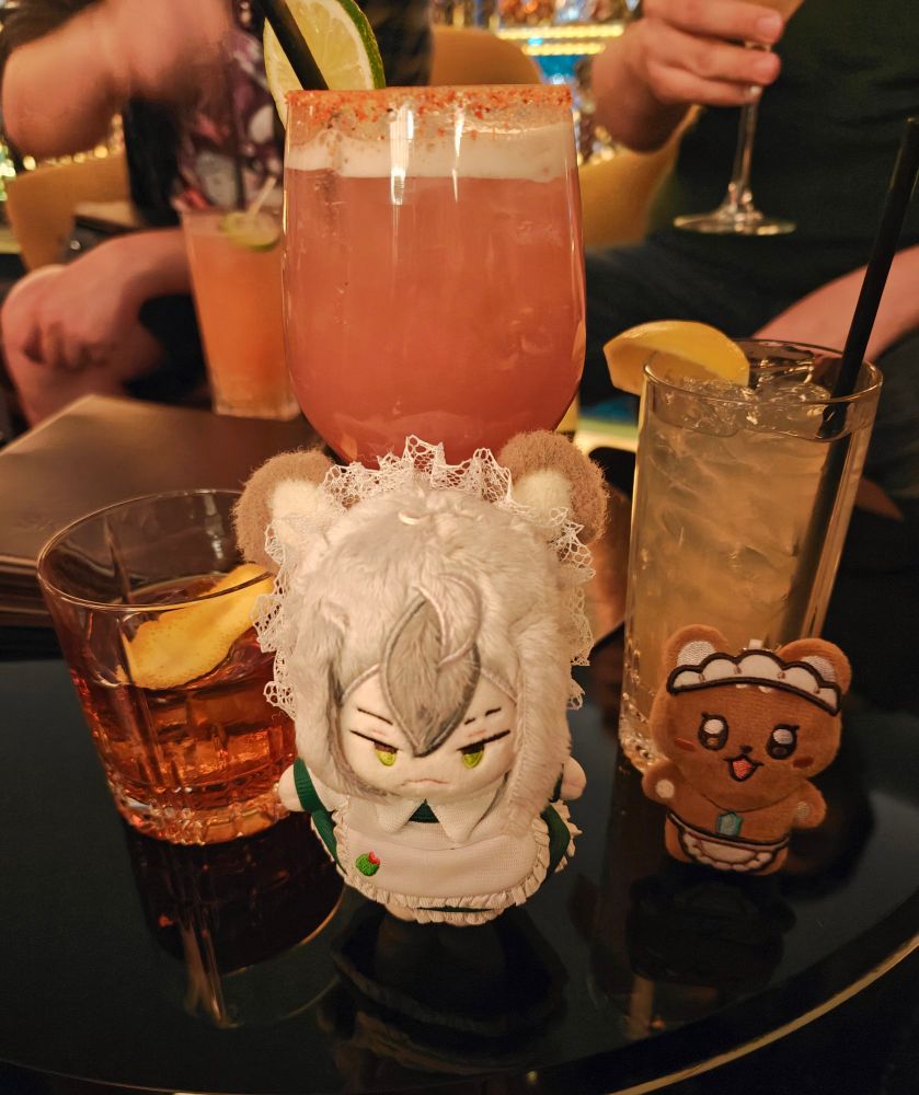 rei and eiden posing in front of three drinks. from left to right: old fashioned, almond blue (+tequila), long island iced tea