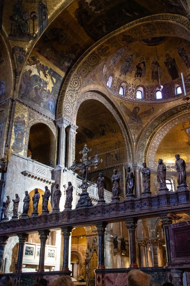 Basílica com interior predominantemente dourado, com estátuas de santos