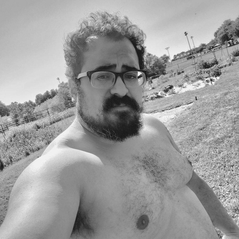 myself shirtless, standing in a garden. the sun is beating down on my back 