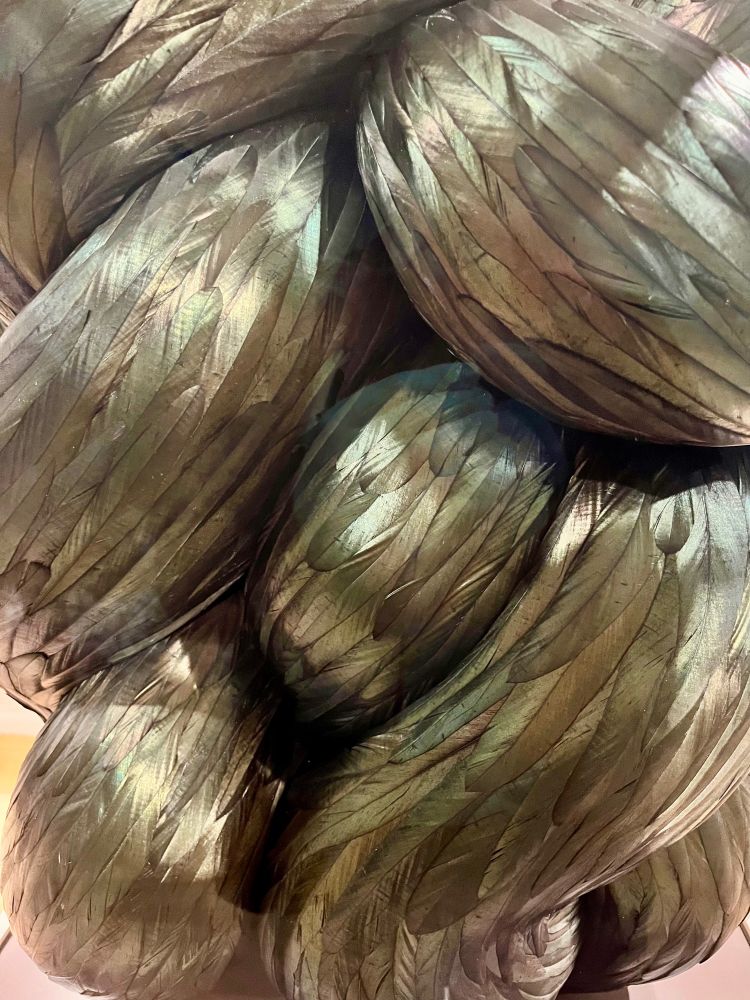 Close up TORSION by Kate MccGwire: A snakelike sculpture, covered in rooster feathers.
