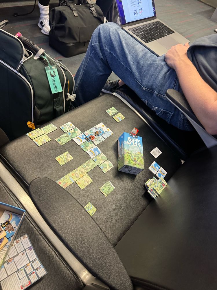 In an airport gate. Playing the game Solstis solo. 