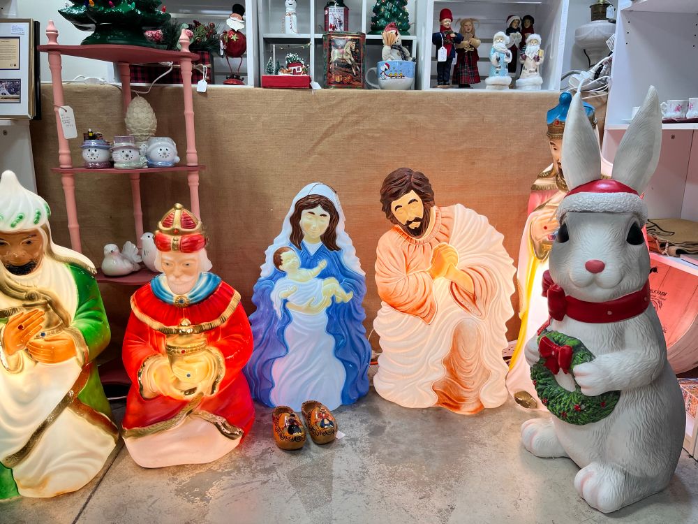 Plastic yard decorations of Mary and Joseph looking lovingly at a pair of wooden shoes, surrounded by some wisemen and a giant rabbit in a Santa hat at our local antique mall.