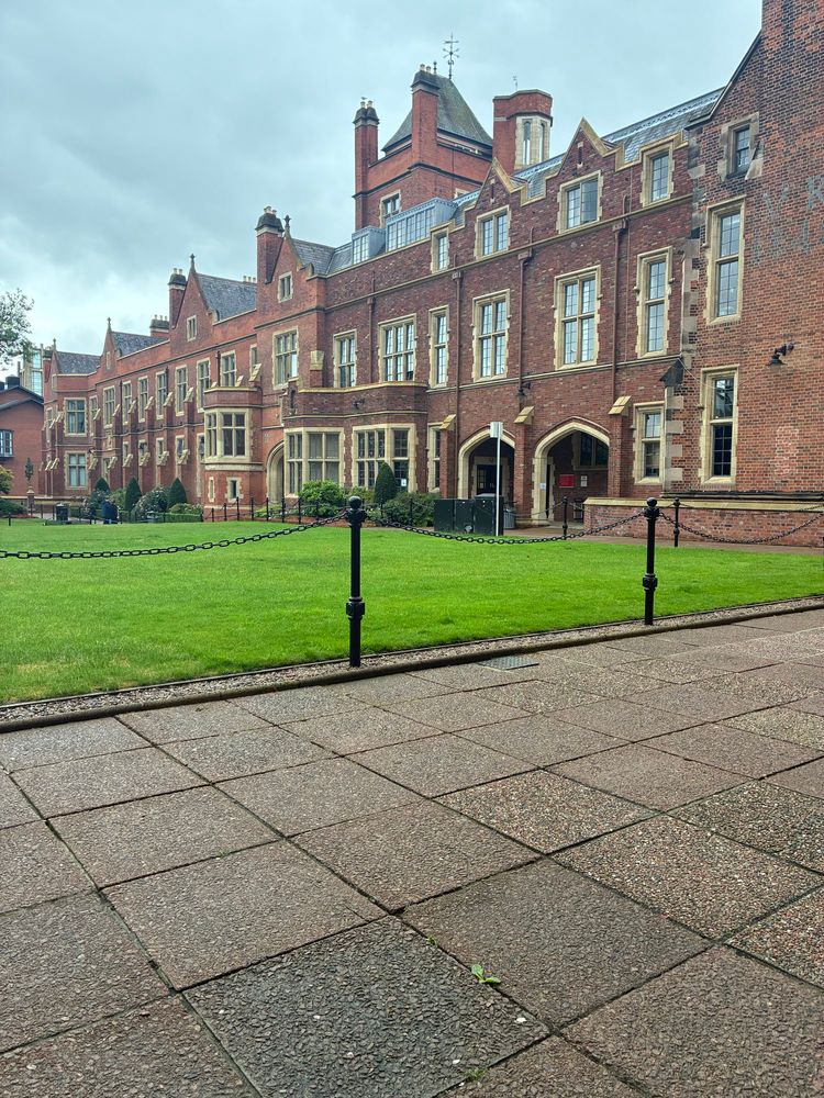 A view of the inner court at Queen’s university, showing a very collegial two story red brick building.