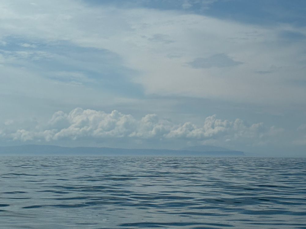 Landfall, Ireland - Country Antrim is seen 12 or so nm ahead. The sea is quite calm, roiled only a little by tide in the North Channel between NI and Scotland.