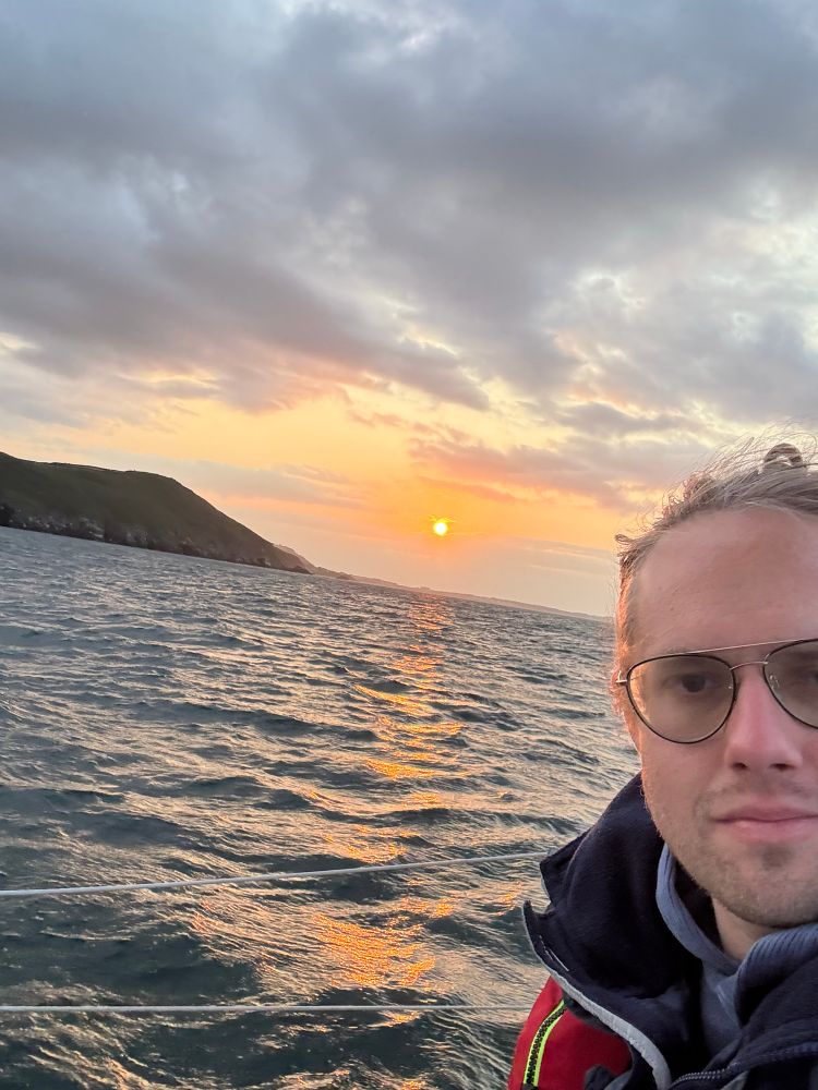 The sunset last night, just before entering Port Mooar. I’m photobombing, foreground right. It’s an orange sunset and an overcast dusk. The point to the north of cove background left.