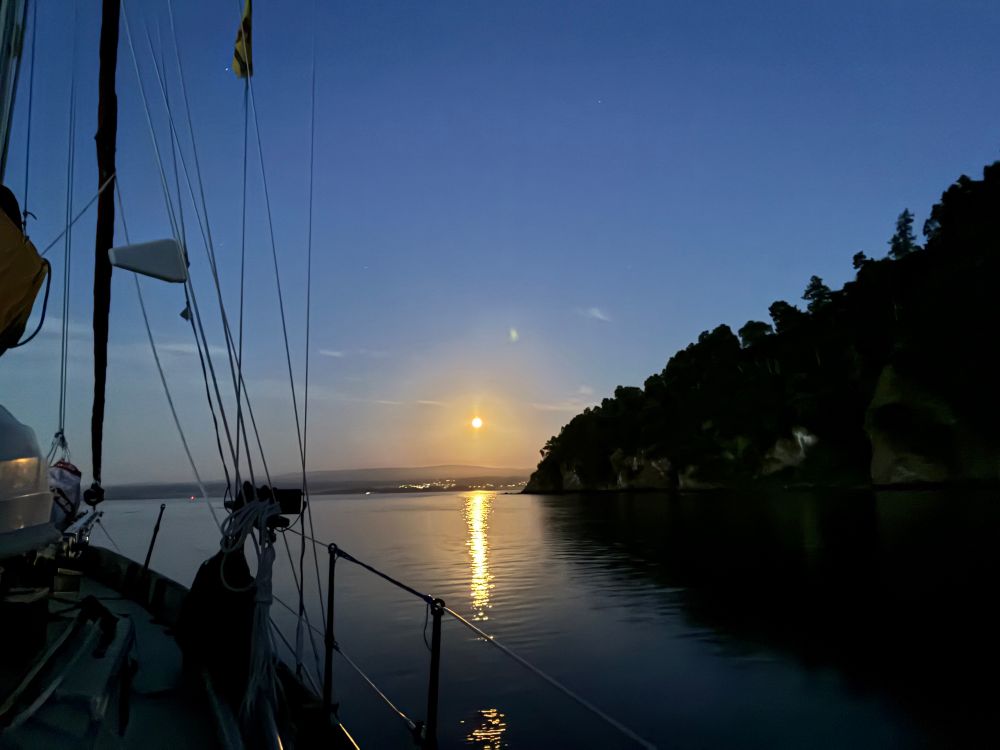 Just after moonrise, looking over Indigo’s bow and anchor towards the bay’s entrance. Inverness is just hidden by the headland to the left. The moon is large and the night is bright and calm.
