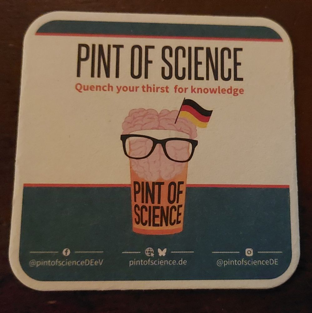 Bierdeckel

Schriftzug:
Pint of science 
Quench your thirst for knowledge

Darunter befindet sich ein Bierglas, in das sich ein Gehirn mit einer Deutschlandfahne quetscht. Es hat eine Brille auf