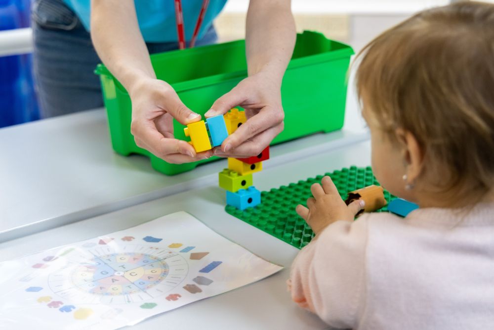 A child watches as duplo blocks are assembled