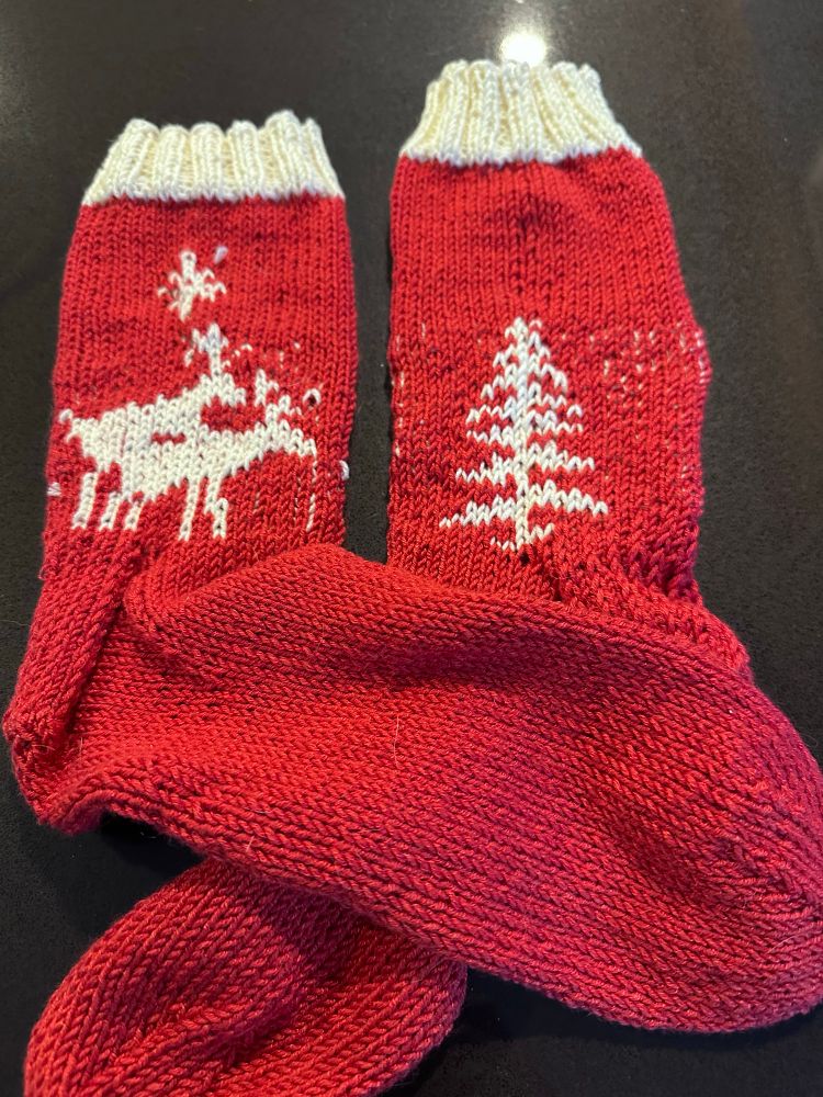Red and white socks with 2 reindeer having sex on one side and a Christmas tree on the other 