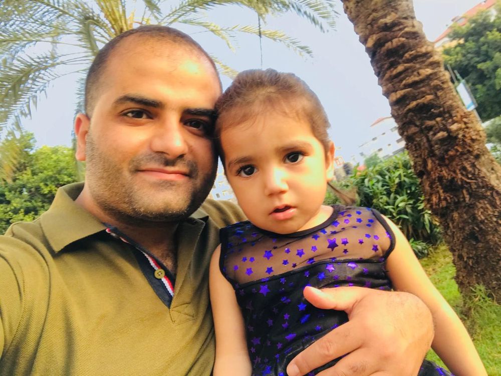 A photo of Majd with his little daughter Mona before displacement and famine.