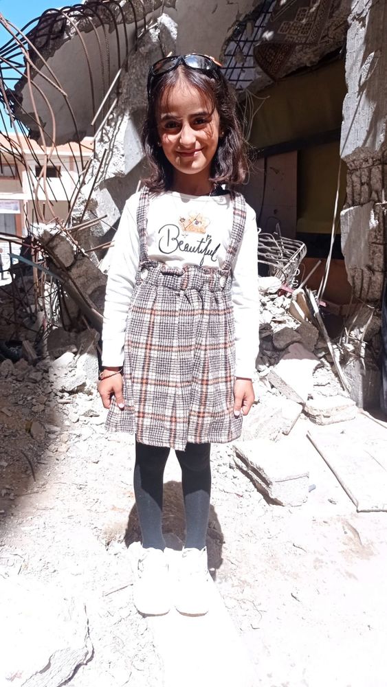 A photo of Amal's and Naser's daughter Rolan. It's a photo from another time, when the family was better off. She is wearing a beautiful dress and smiling at the camera.