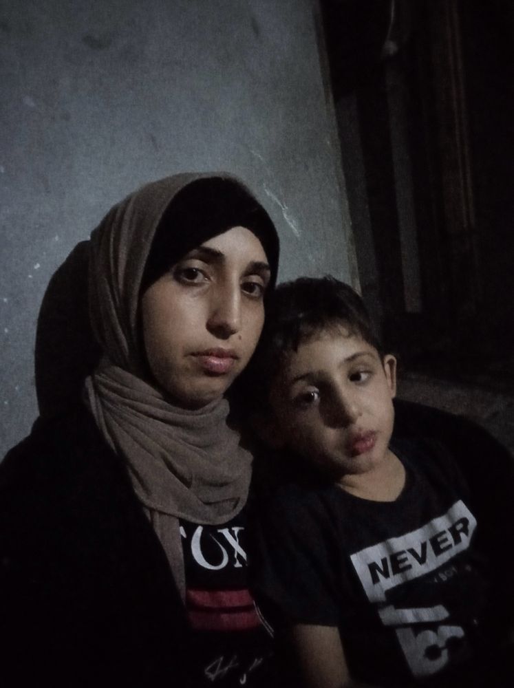 A photo of Lubna with her son Nasser, who suffers from grapples with a thyroid condition and stunted growth.
The photo is taken while displacement and famine in genocide.