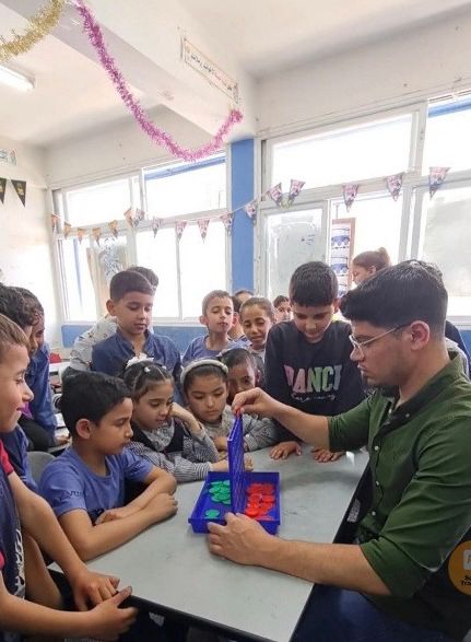 A photo of Mihammed, playing with children at the kindergarten.