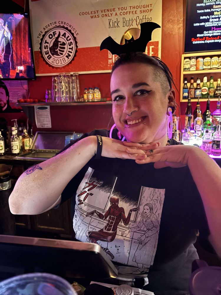 Photo of myself posing in front of the bar wearing a bat headband 