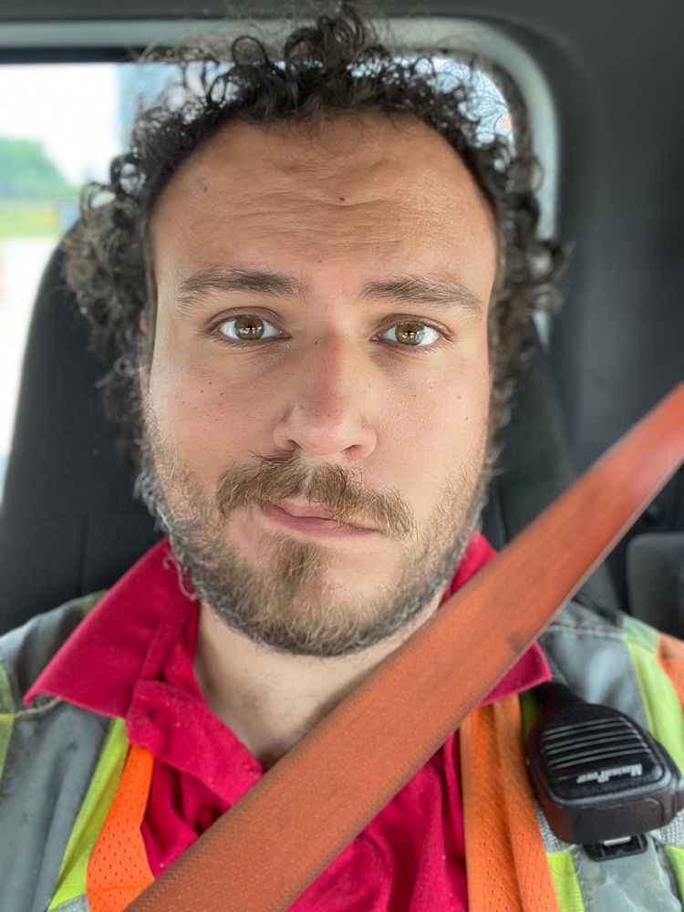 Hair is a bit messy while I'm sitting in the day cab waiting in my ubiquitous polo (in red) and high-vis vest. Probably need to shave a little. 