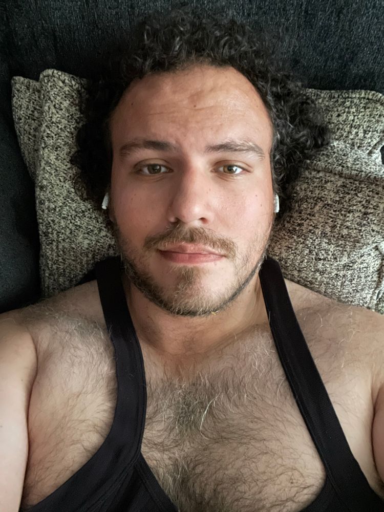 Me in a black tank top looking at the camera with sensual intent. 