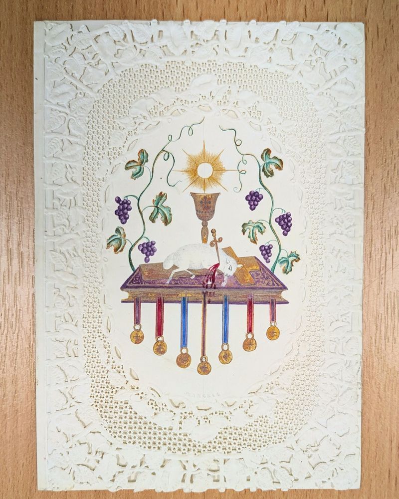 Victorian easter card depicting a lamb being slaughtered on an alter surrounded by grapes and a chalice. Printed on beautiful delicate embossed lace-paper