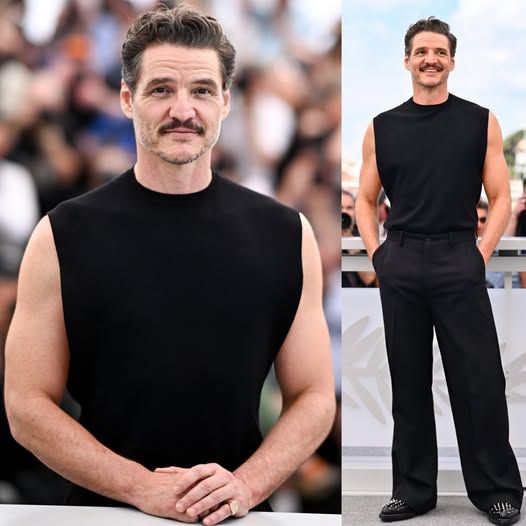 A photo of Pedro Pascal wearing black trousers, a black muscle tank, and a pair of black boots with studs.