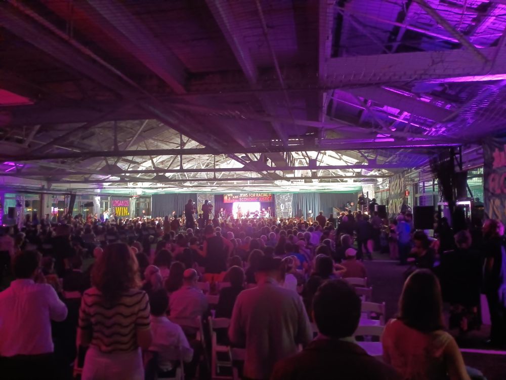A warehouse sized room, dimly lit with a stage at the opposite end and a full audience watching. (I was told there were 1100 people)