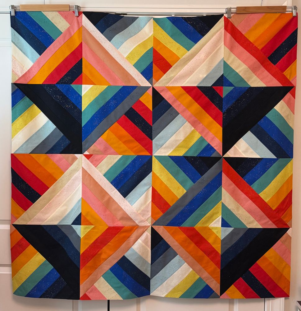 Photo a quilt top with rainbow colors in geometric patterns. 