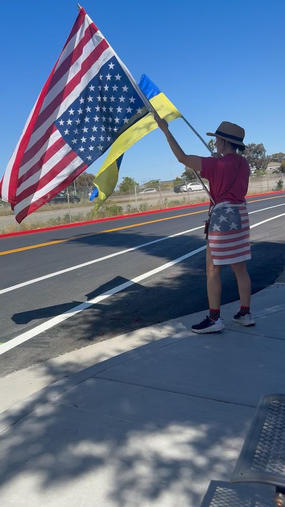 Enthusiastic citizen waving USA and Ukranian flags.