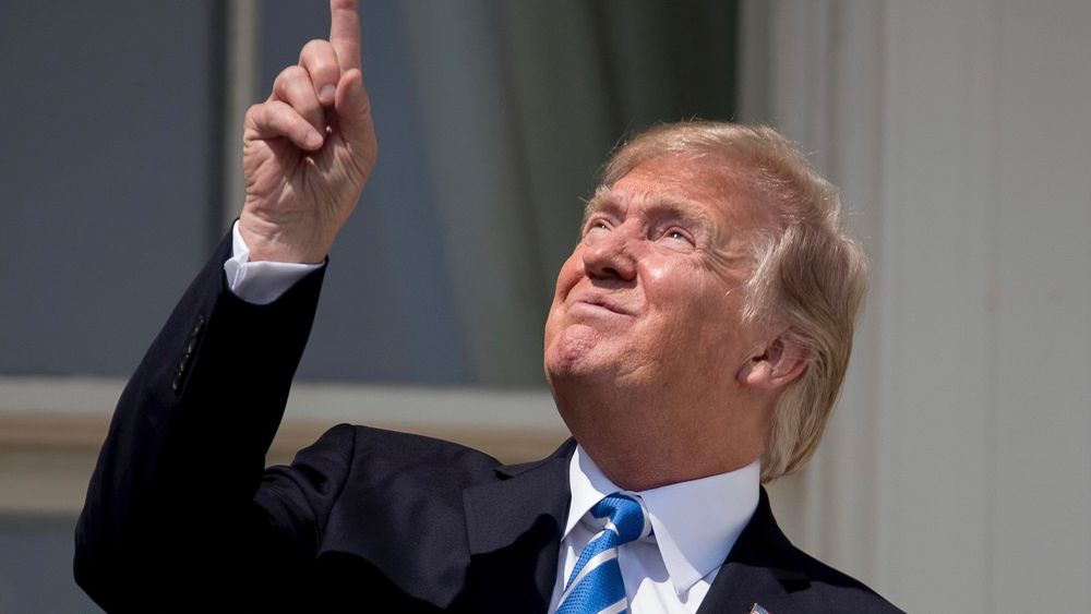Trump pointant du doigt le soleil sans lunettes de protection pendant une éclipse 