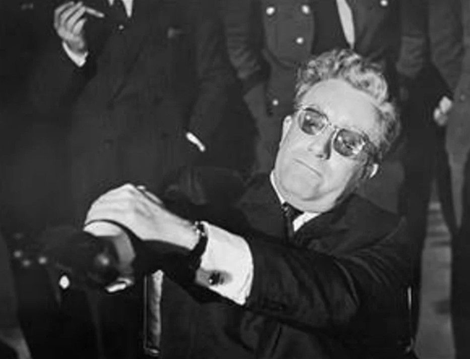 Photo of Peter Sellers as Dr Strangelove suppressing his desire to do a Nazi salute. 