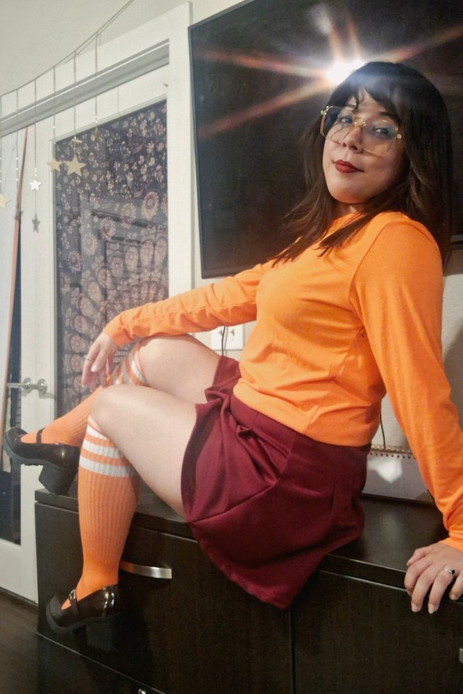 Orange shirt red skirt, lady dressed up as velma from scooby doo