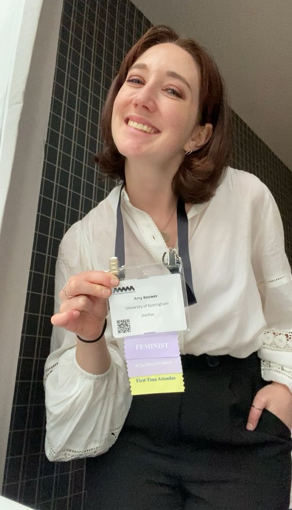 Picture of me (brunette, white 20-something in her best white billowy shirt and black trousers) smiling and holding my name tag for the NWSA annual conference.