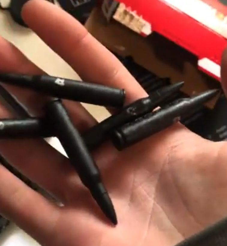 large, black-painted bullets in their hand