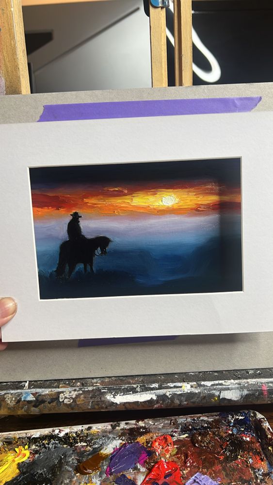 Kleines Ölgemälde von einem Sonnenuntergang. Schemen von Bergen sind zu sehen. Im Vordergrund schattenhaft, ein Reiter auf seinem Pferd 
