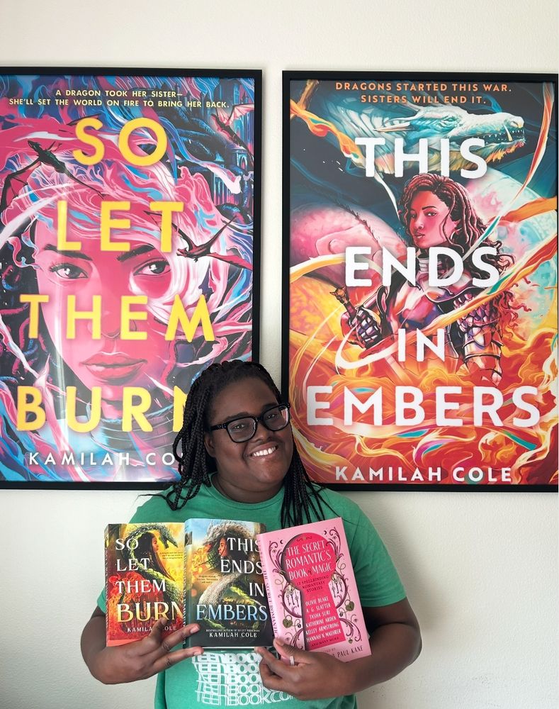 me holding up my books i have copies of in front of my poster size book covers