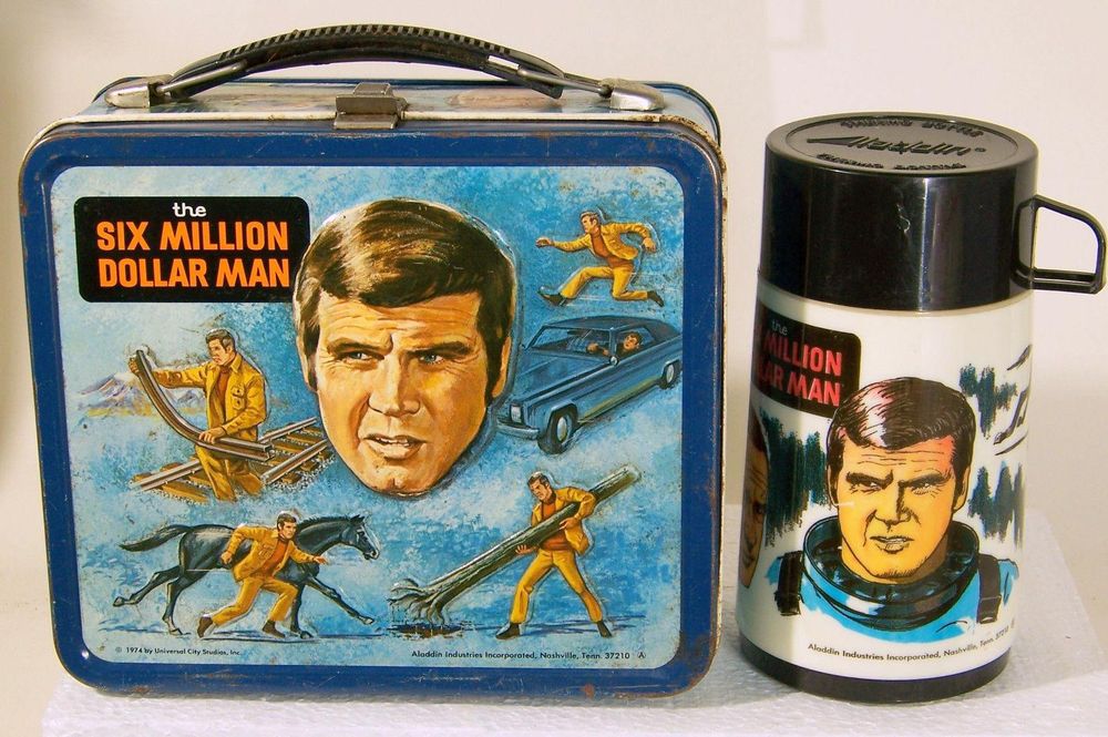 A Six Million Dollar Man lunchbox with thermos. Steven Austin's head is surrounded by images of his strength and speed: bending a railroad tie, racing a stallion, ripping a tree out of the ground, jumping over a speeding car.