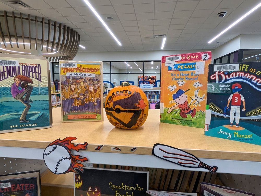 4. A Blue Jays themed book display featuring a pumpkin painted with the team logo and children's books about baseball.