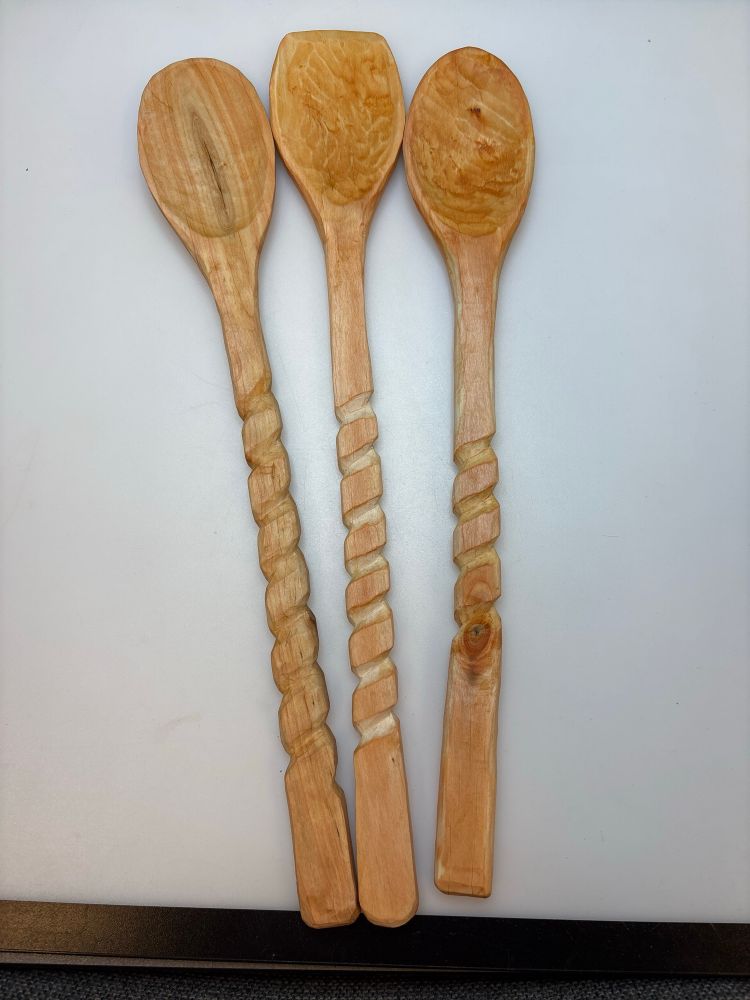 Three wooden spoons with spirals carved into the handles. 