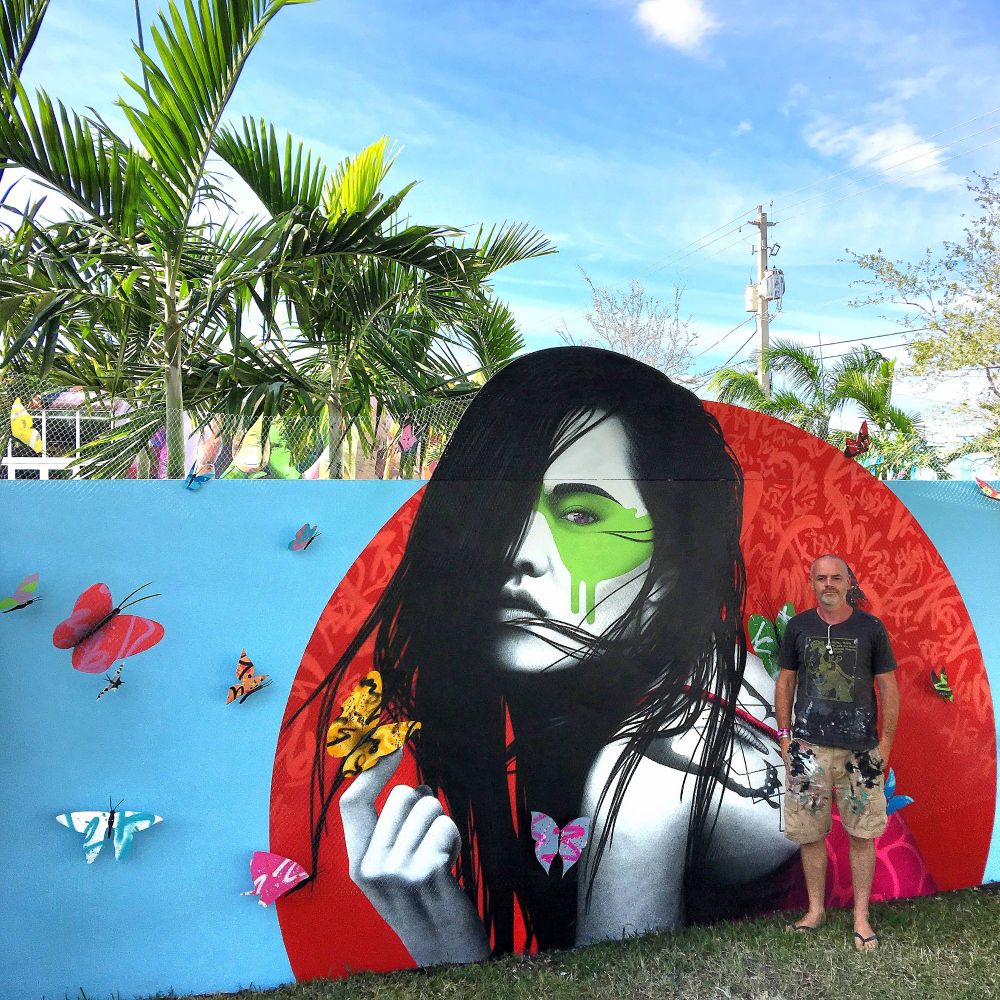 Artist FinDAC poses in front of his mural for Wynwood Walls in Wynwood in Miami, Florida.