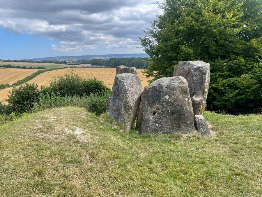 Ancient stones on a hill stare down on a distant field.