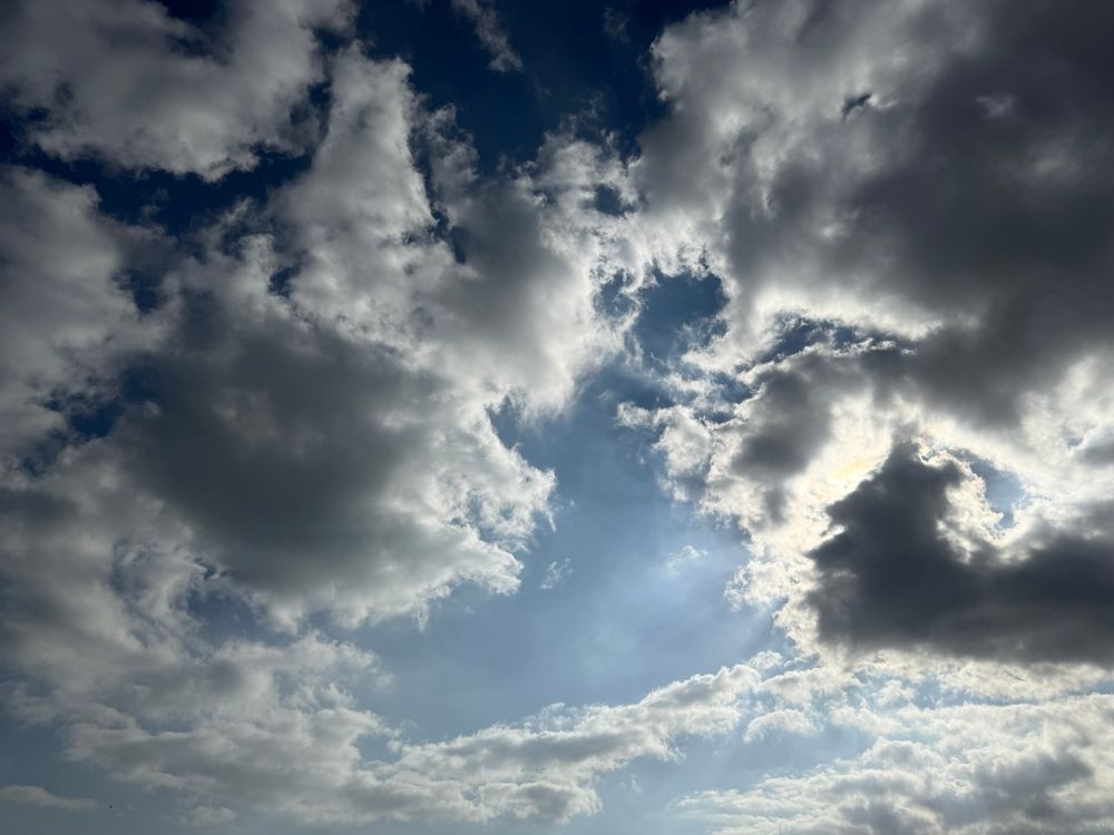 Dark clouds surround a blue sky